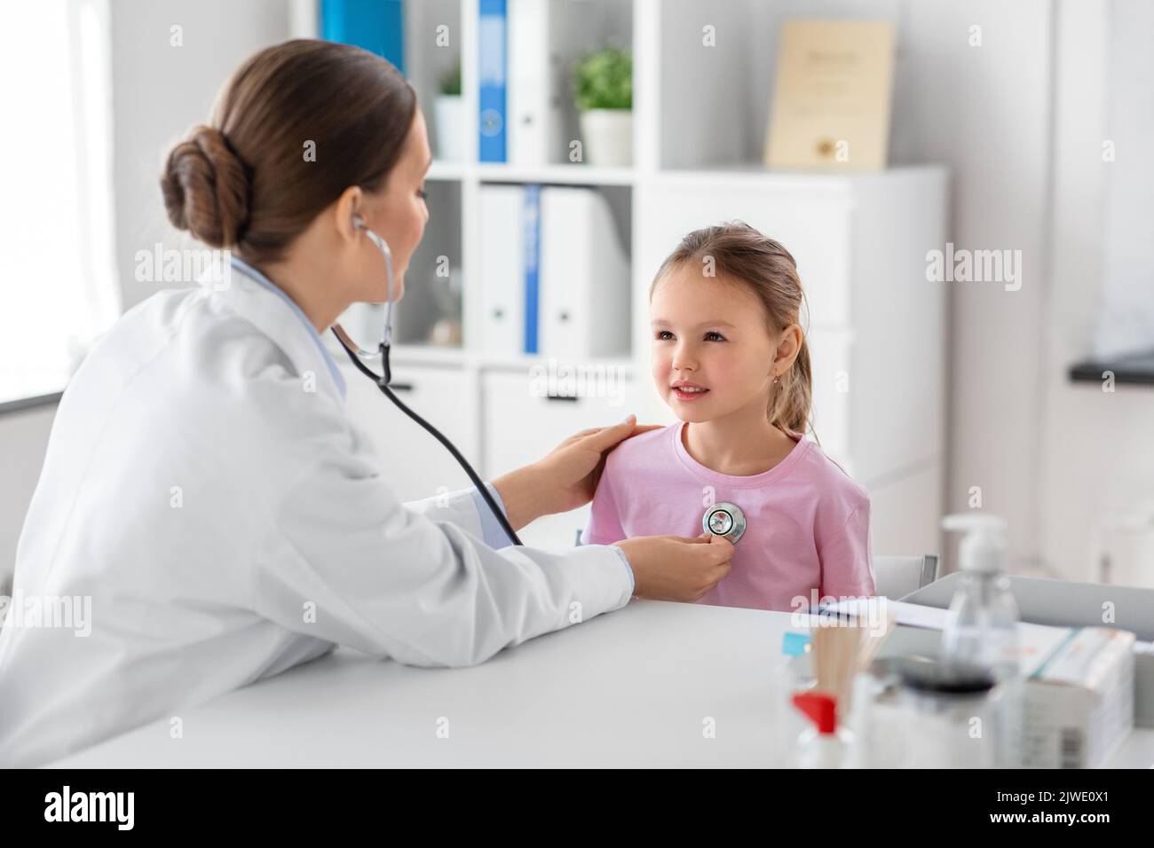 médico con estetoscopio y paciente niña en la clínica Foto de stock