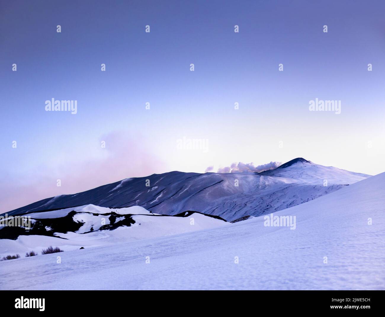 Etna - Suggestivo paesaggio Invernale con neve al tramonto durante la hora azul sul vulcano Etna al crepuscolo - Sicilia Foto de stock