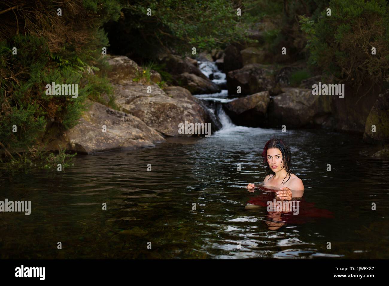 Ahermosa mujer enfriándose en un arroyo de montaña Foto de stock
