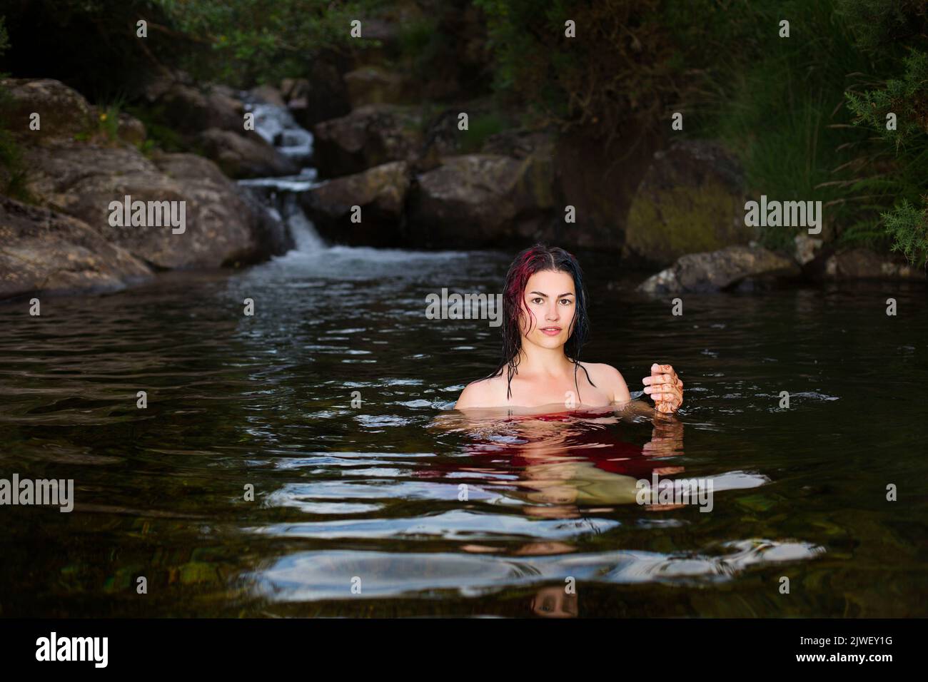 Ahermosa mujer enfriándose en un arroyo de montaña Foto de stock