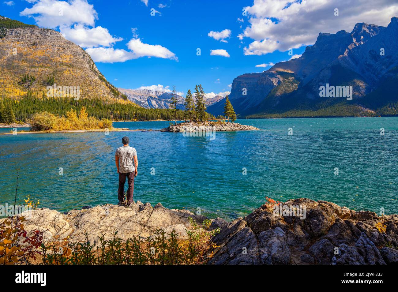 Joven excursionista parado en el Lago Minnewanka en Banff National Park, Canadá Foto de stock