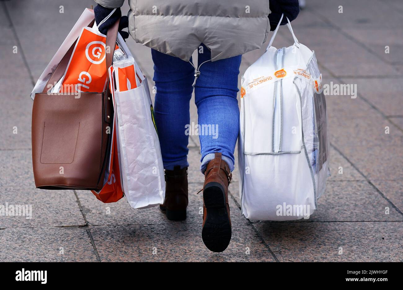 Foto de archivo de fecha 26/11/21 de una mujer que llevaba varias bolsas de compras. Según nuevas cifras, los británicos desaceleraron sus hábitos de gasto durante el mes pasado en medio del alza inminente de las facturas de energía de los hogares. Fecha de emisión: Martes 6 de septiembre de 2022. Foto de stock