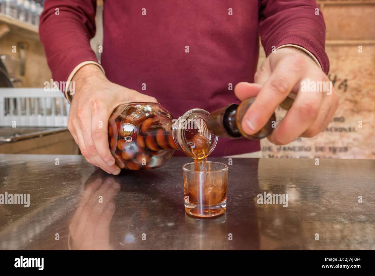 Barman Vertiendo en vasos de licor de cereza Ginjinha en Lisboa, Portugal Foto de stock