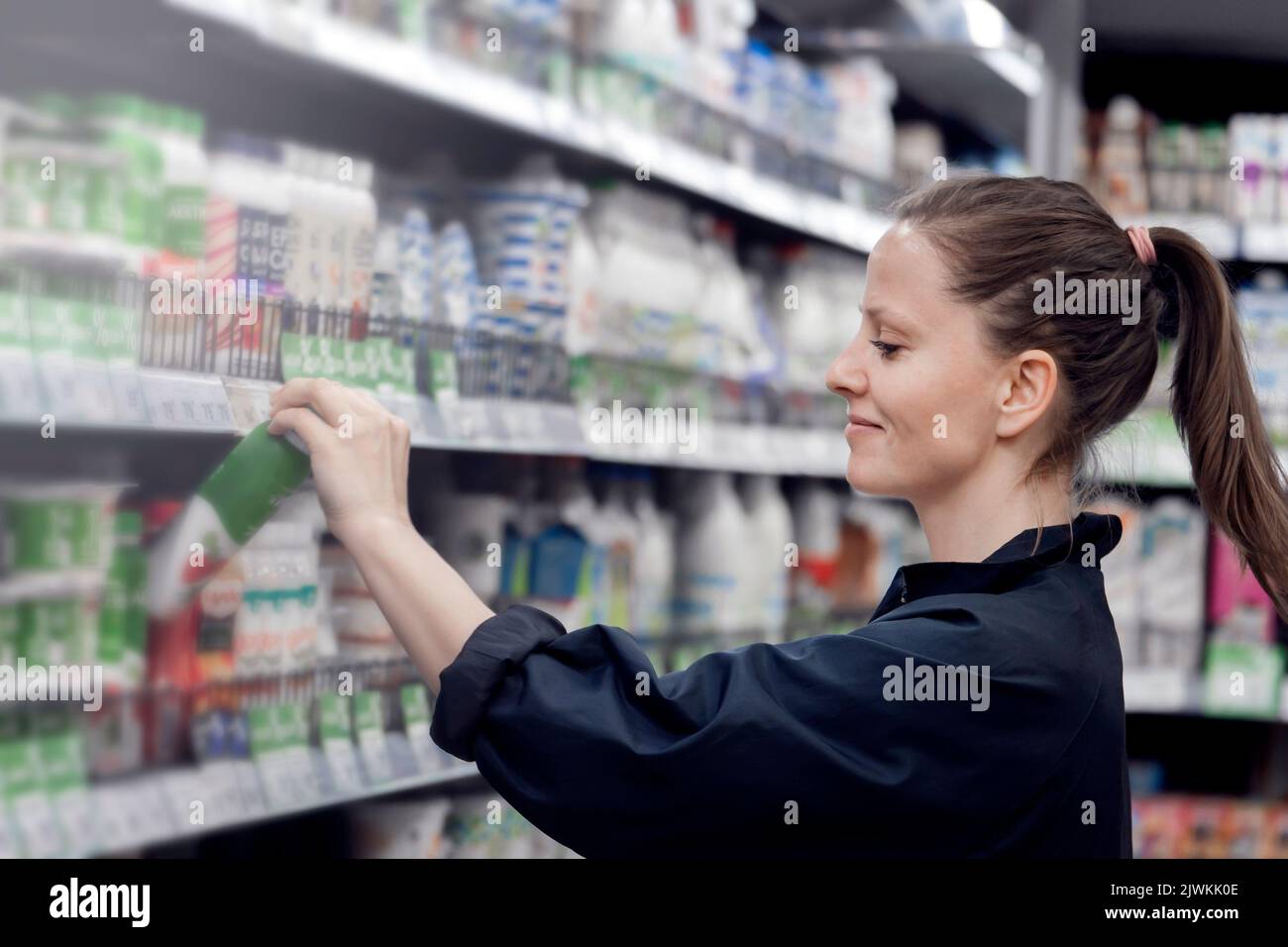 Una señorita sonriente toma provisiones del mostrador de un escaparate