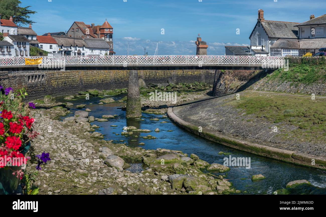 El puente peatonal que cruza el West Lyn River que atraviesa el centro de la aldea costera de North Devon hasta llegar al pequeño y pintoresco puerto. Lynmouth s Foto de stock