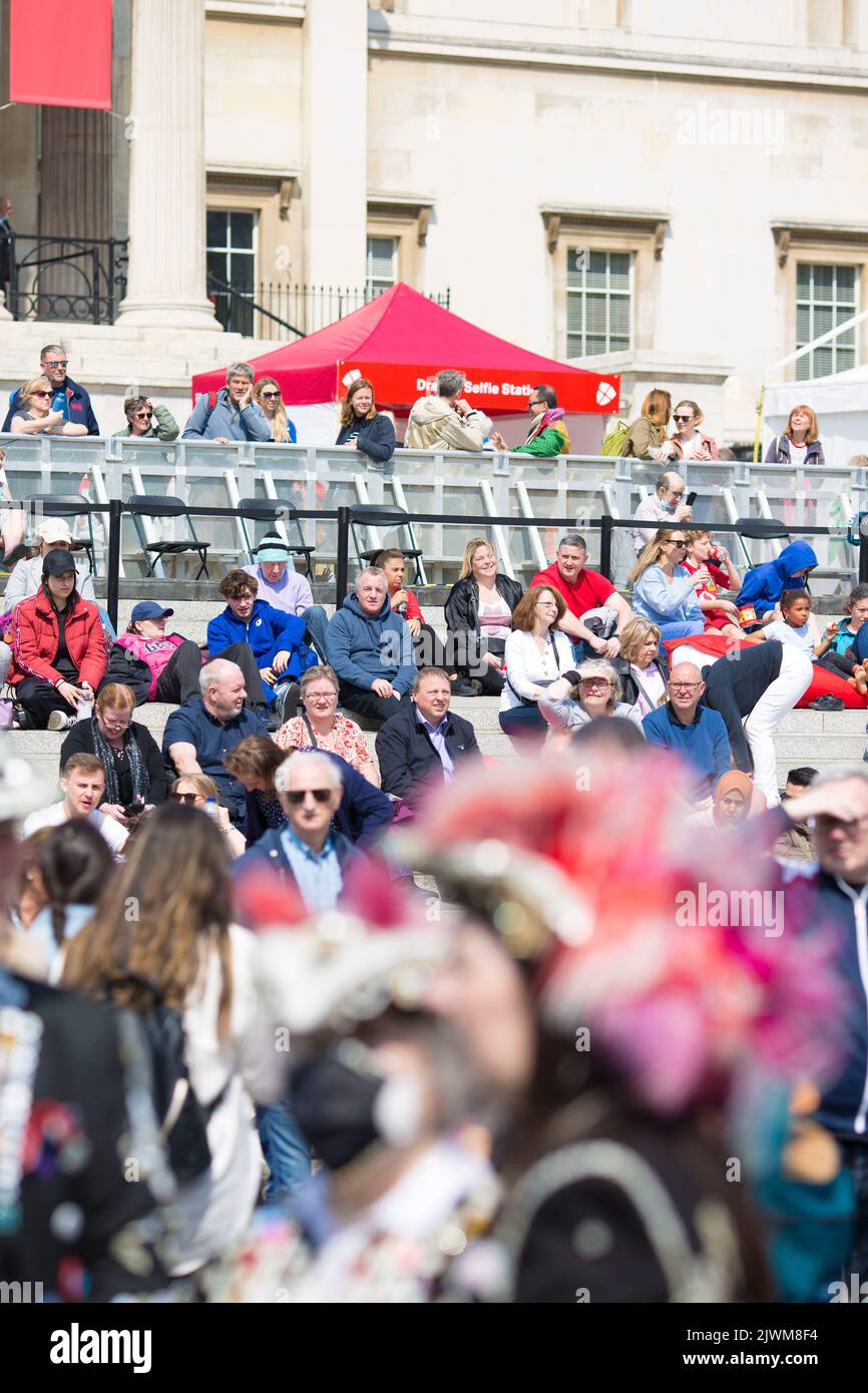 La gente mira a los Reyes Magos y Reinas mientras se reúnen para las celebraciones del Día de San Jorge en Trafalgar Square, en el centro de Londres. Foto de stock