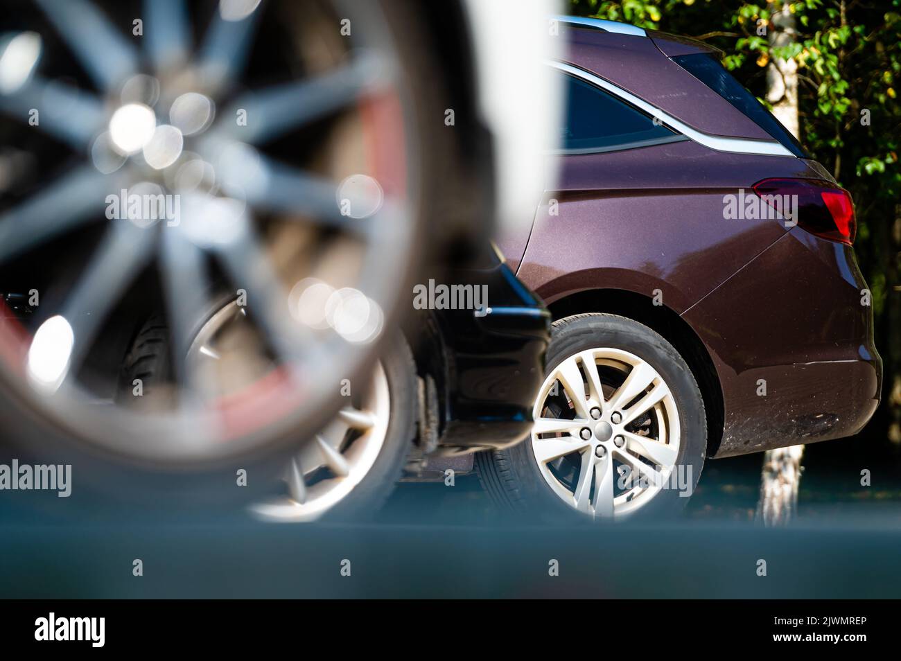 primer plano de las ruedas y parachoques de un coche aparcado en el patio de una casa residencial, sección inferior Foto de stock
