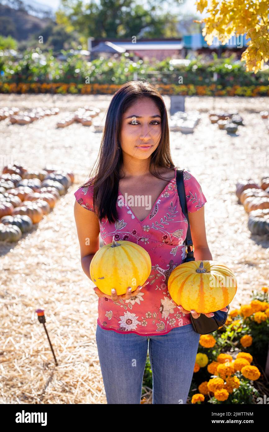 Celebración de Otoño Retrato de una joven Asiática con dos calabazas en una granja Foto de stock