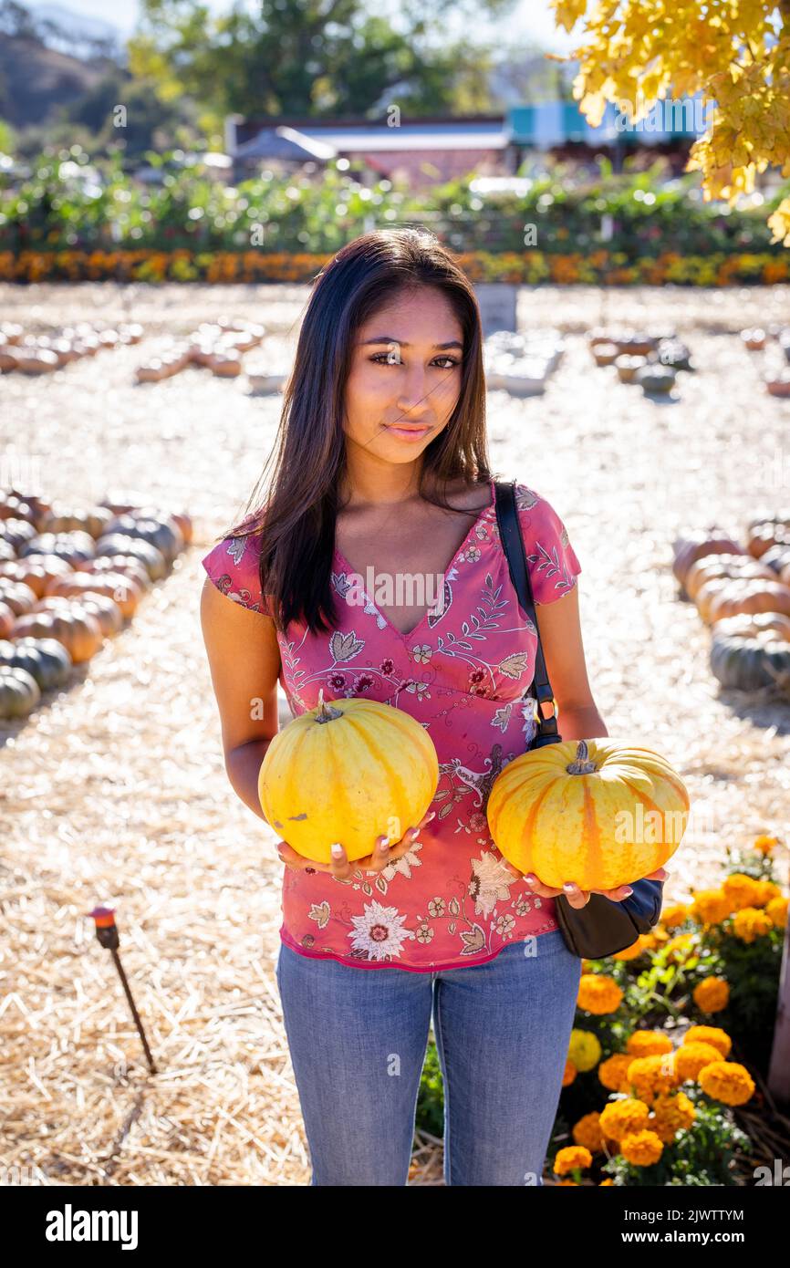 Celebración de Otoño Retrato de una joven Asiática con dos calabazas en una granja Foto de stock