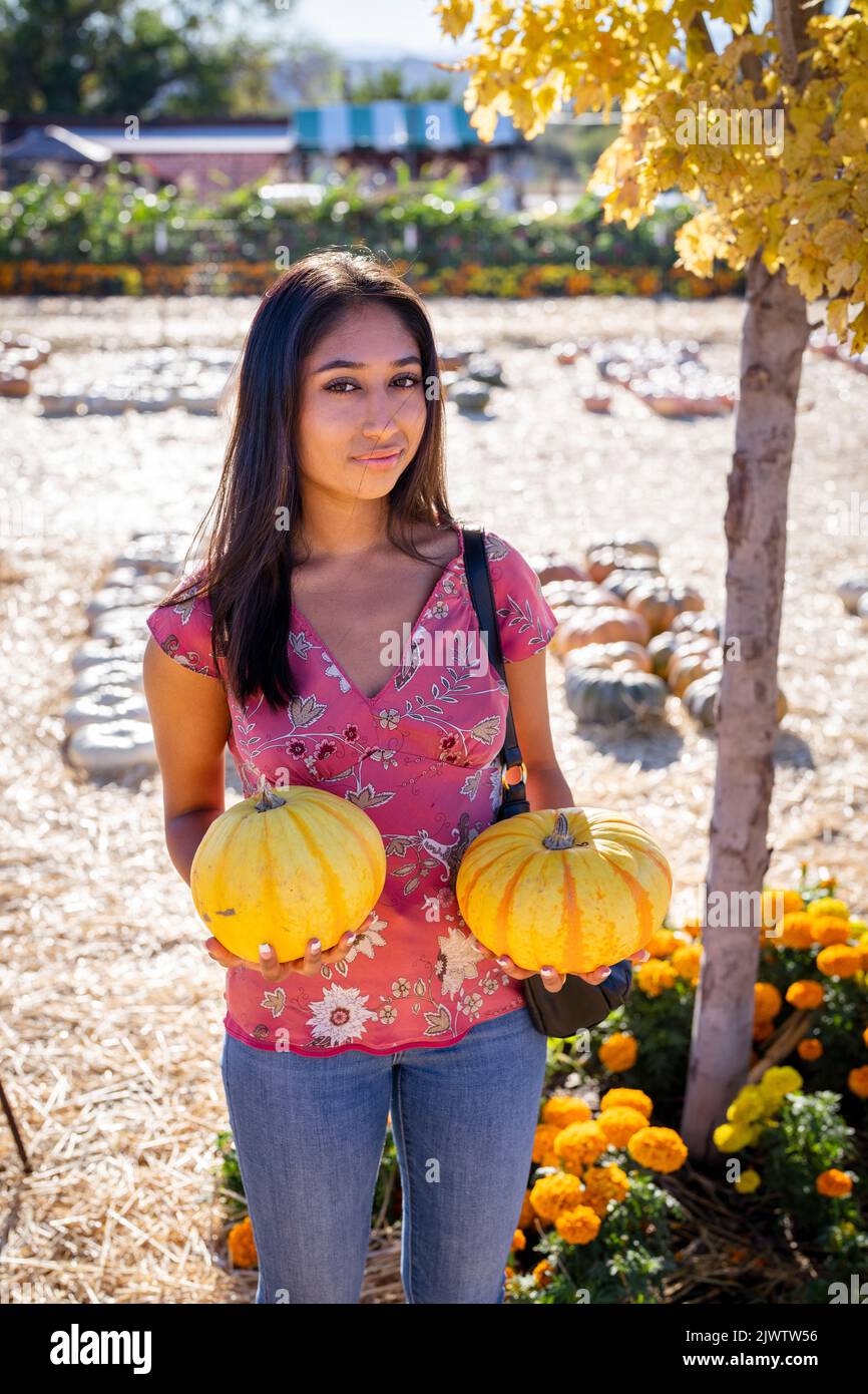 Celebración de Otoño Retrato de una joven Asiática con dos calabazas en una granja Foto de stock