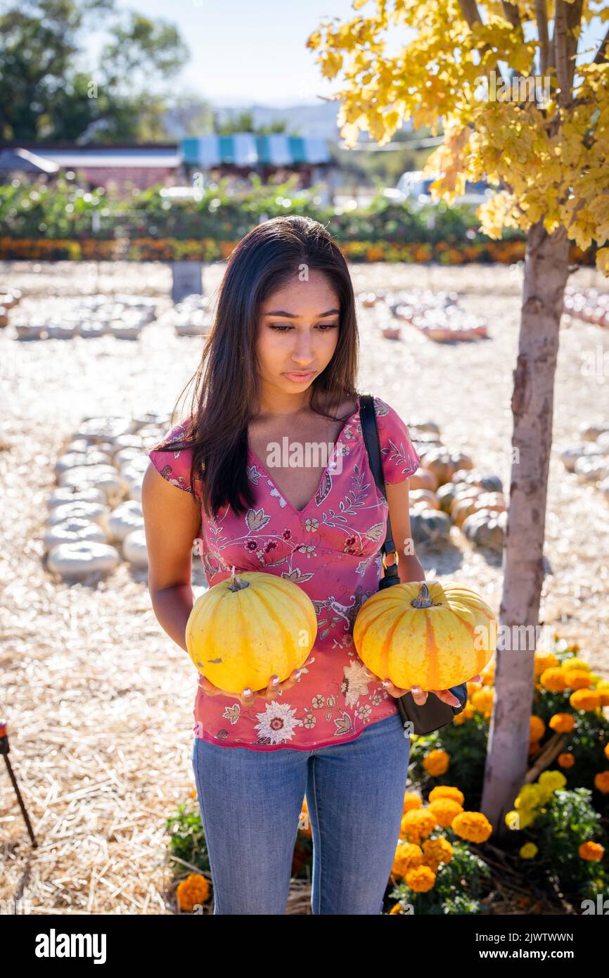 Celebración de Otoño Retrato de una joven Asiática con dos calabazas en una granja Foto de stock