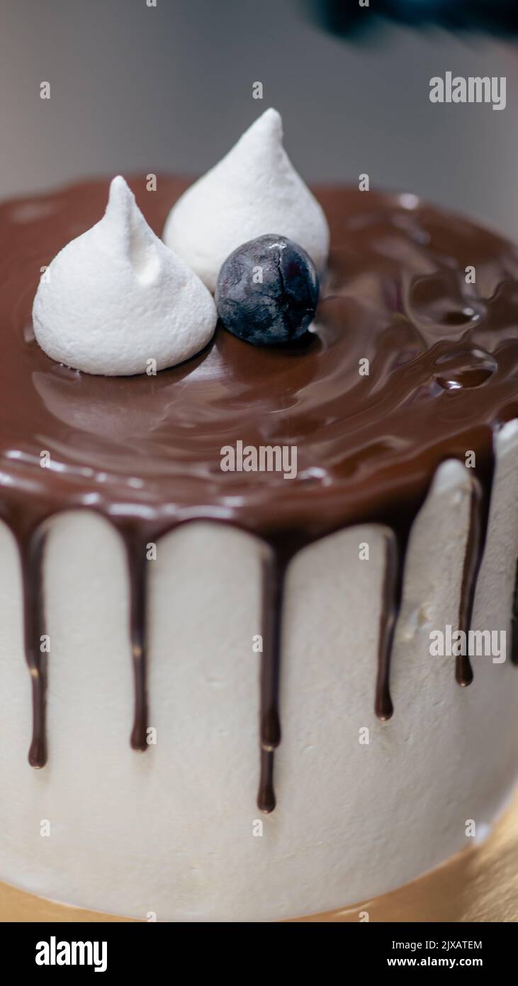 trabajador irreconocible preparando una torta de chocolate y bayas que gotean dulces Foto de stock