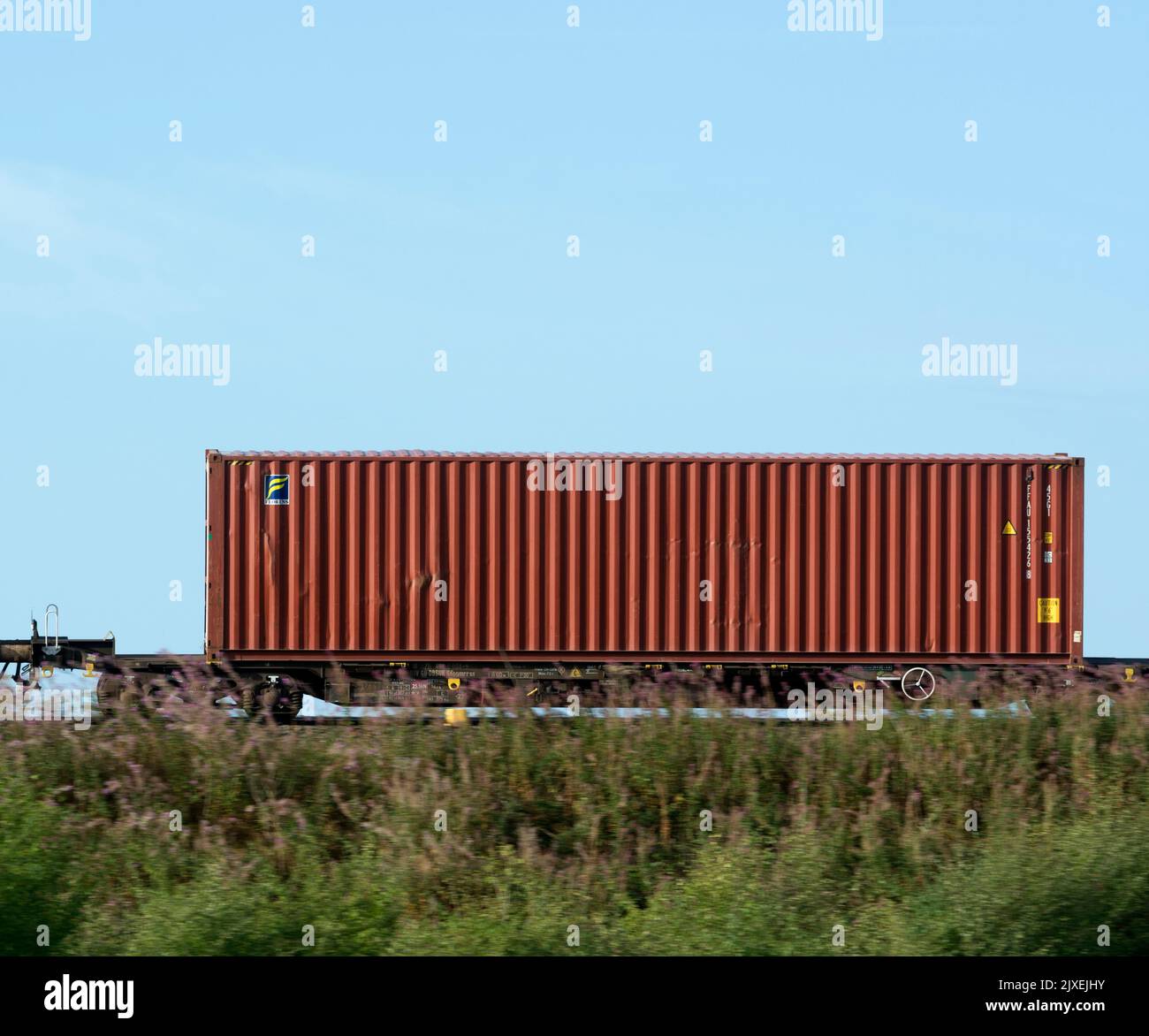 Contenedor de envío Florens en un tren freightliner, Warwickshire, Reino Unido Foto de stock