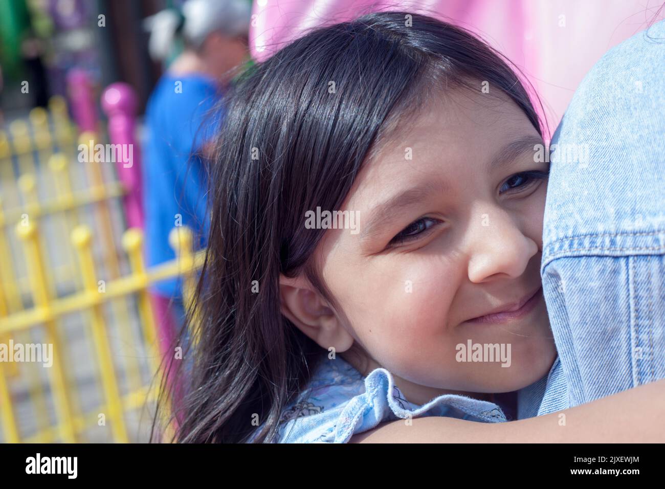 Primer plano abstracto de una niña (seis años) abrazando a un hermano mayor. Foto de stock