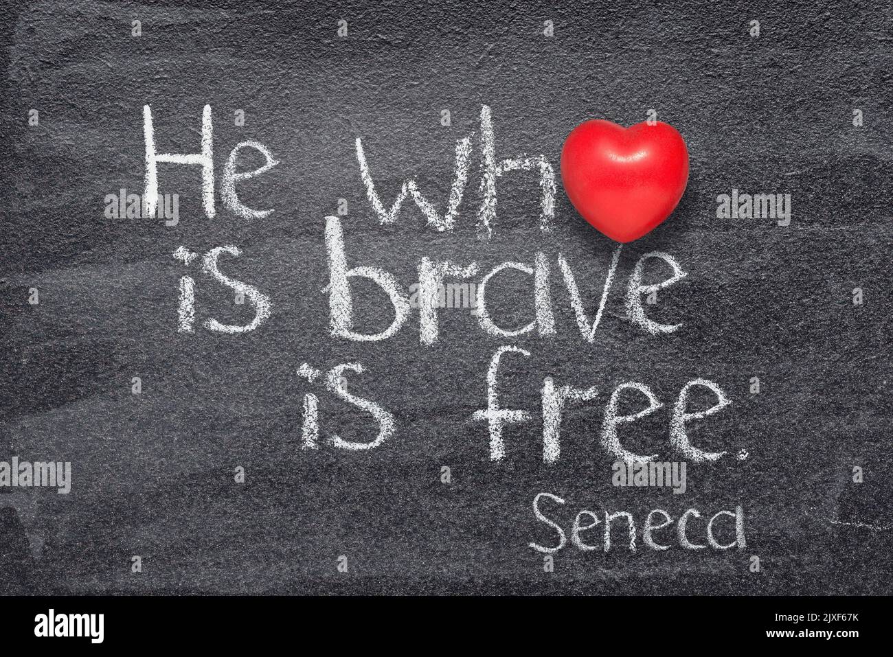 Quien es valiente es libre - cita del antiguo filósofo romano Séneca escrita en pizarra con corazón rojo en lugar de O Foto de stock