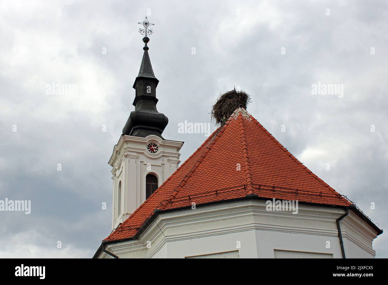 Lugares famosos, la iglesia de San Mateo con nido de cigüeña, Stitar, Eslavonia, Croacia Foto de stock