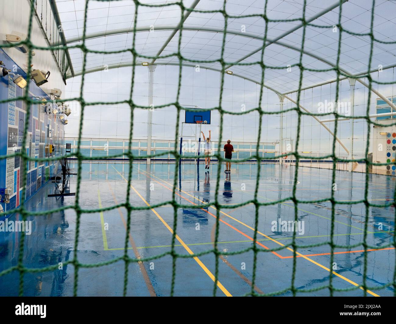 Es un día de navegación mojado en un crucero en el Mar del Norte. Entonces, ¿qué mejor cosa a hacer que una cierta práctica del baloncesto... realmente? Tal agudeza. Foto de stock