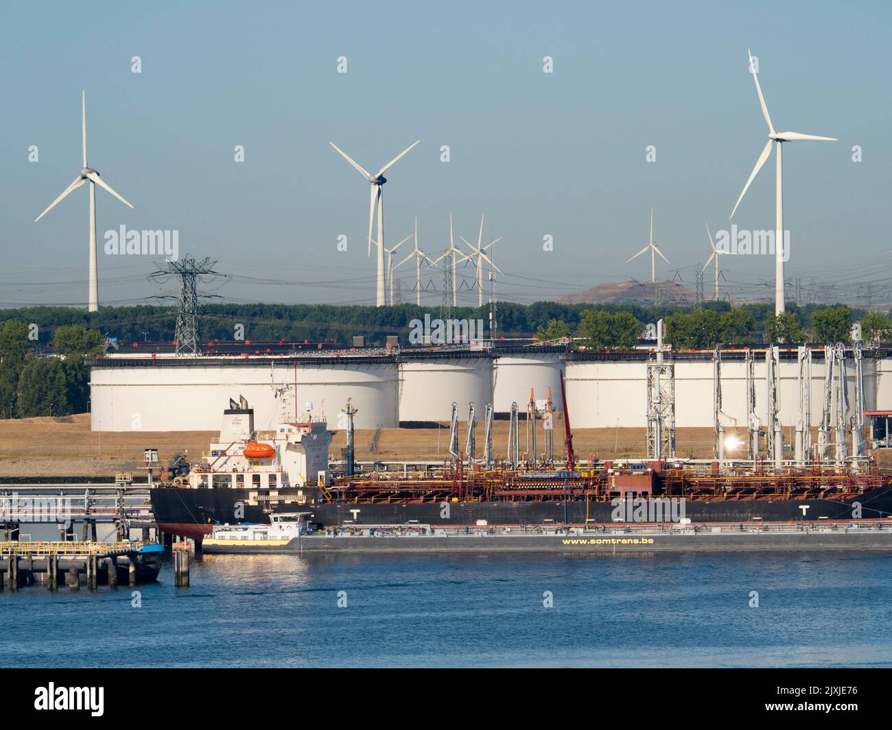 Pasado y futuro del suministro energético: Turbinas eólicas y tanques gigantescos de almacenamiento de petróleo en las afueras de Rotterdam, Países Bajos. El puerto de Rotterdam es el LA Foto de stock