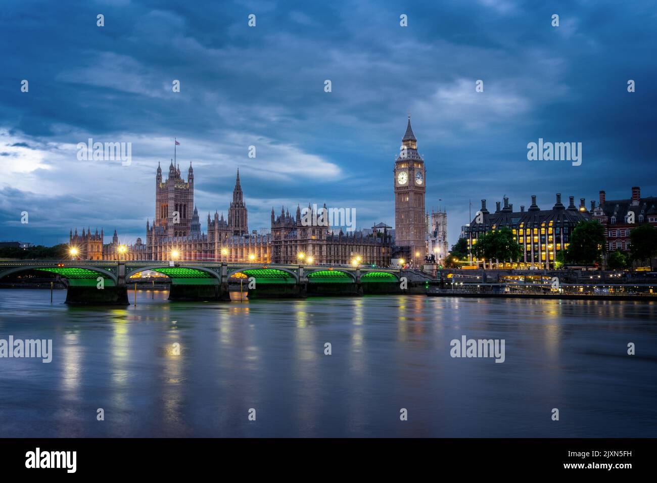 Vista del palacio de Westminster y el puente sobre el río Támesis con el Big Ben iluminado por la noche en Londres, Reino Unido Foto de stock