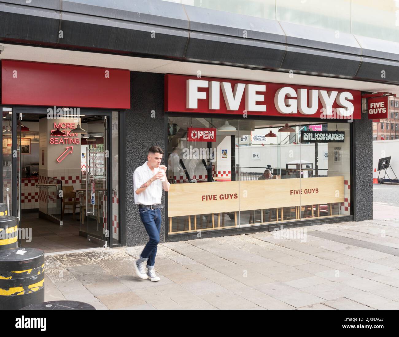 Hombre dejando un restaurante de cinco chicos llevando una bebida en Newcastle, Inglaterra, Reino Unido Foto de stock