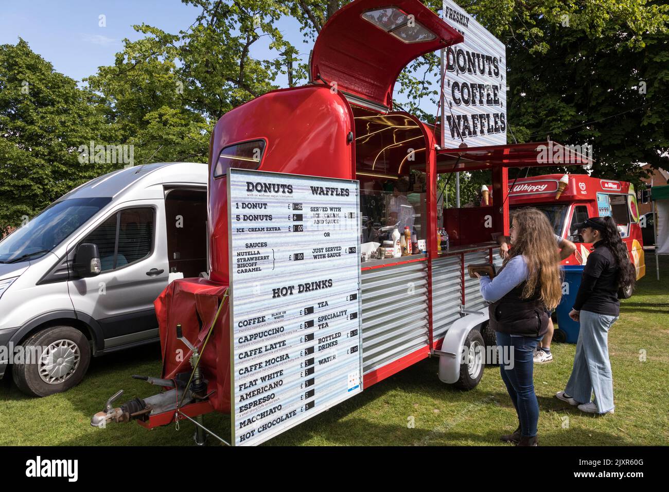 Tráiler de comida y bebida de color rojo brillante en un evento al aire libre, Inglaterra. Foto de stock
