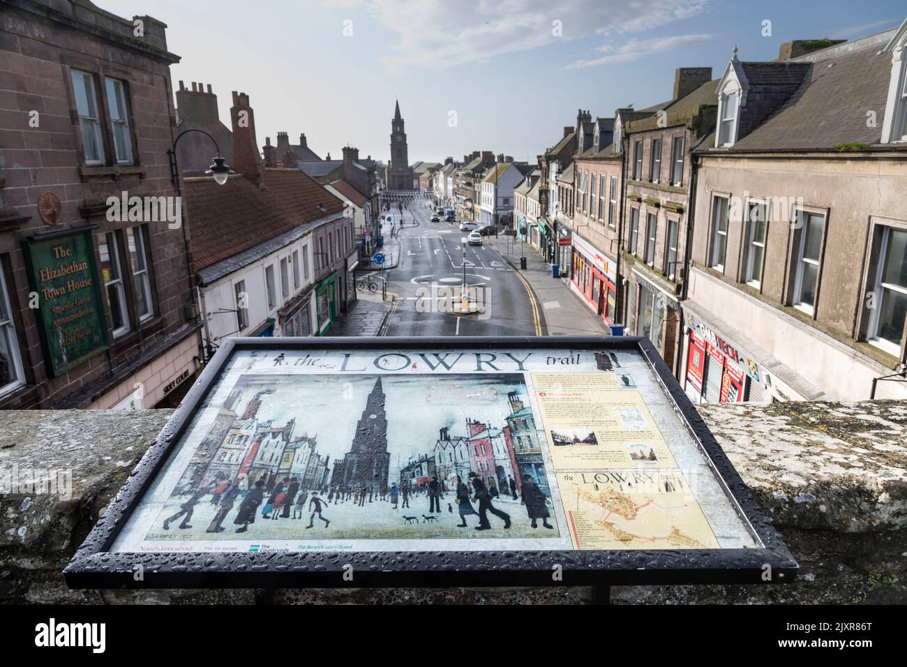 El Ayuntamiento Berwick-upon-Tweed en la distancia con una réplica de una pintura LS Lowry de la escena en primer plano. Foto de stock