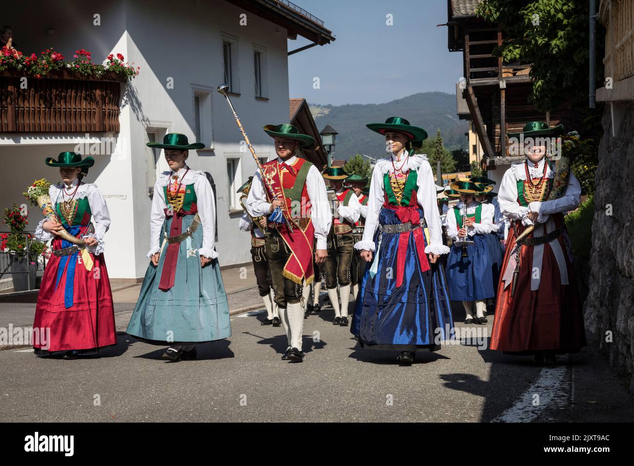 Los hombres y mujeres que visten el traje tradicional de la época local con sombreros de ala ancha y calzones de cuero o faldas largas participan en un churc de 'Corpus Christi' Foto de stock