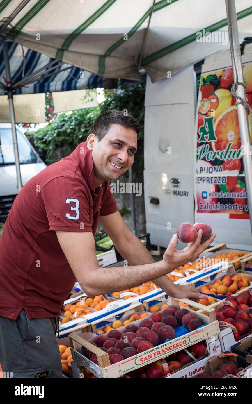 El comerciante del mercado muestra su fruta en su puesto, Italia Foto de stock
