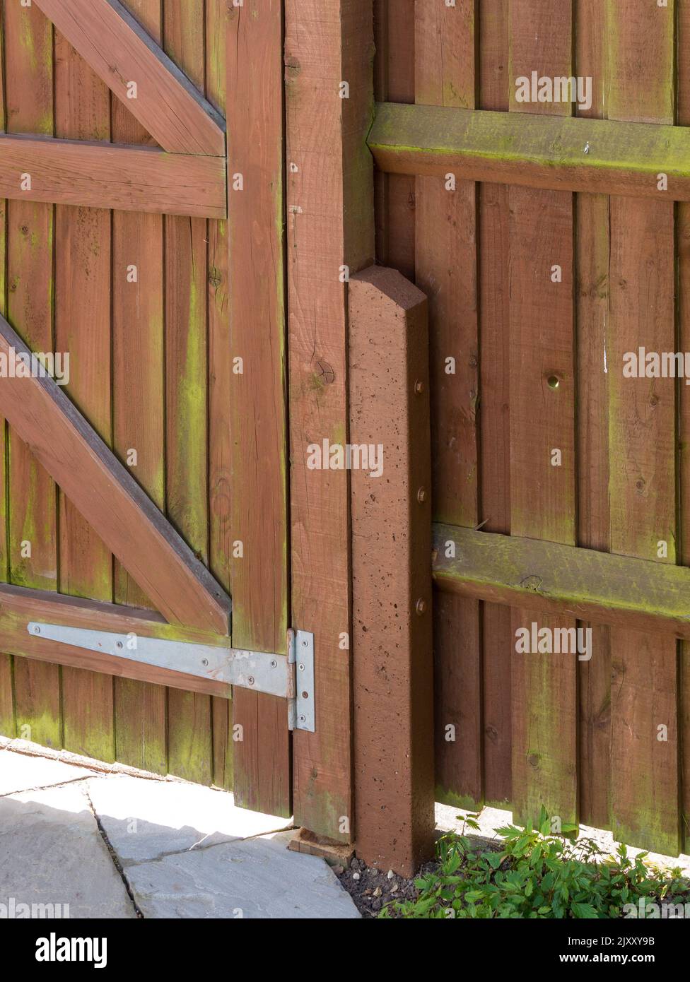 Espuela de poste de valla de 'padrino' de hormigón armado utilizada para reparar el poste de madera de la puerta y apoyar la valla de riel con cubos Foto de stock