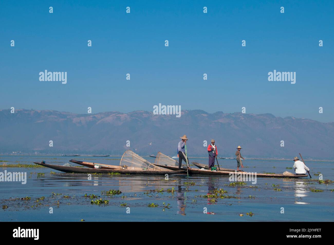 Birmania / Myanmar: Los pescadores Intha que reman en la pierna en el lago Inle, estado de Shan. El Lago Inle es un lago de agua dulce situado en el estado de Shan. Es el segundo lago más grande de Myanmar y uno de los más altos a una altitud de 880 m (2.900 pies). La gente del Lago Inle (llamada Intha), unos 70.000 de ellos, viven en cuatro pueblos que bordean el lago, en numerosos pueblos pequeños a lo largo de las orillas del lago, y en el mismo lago. La población consiste predominantemente de Intha, con una mezcla de otros Shan, Taungyo, Pa-O (Taungthu), Danu, Kayah, Grupos étnicos de Danaw y Bamar. Foto de stock