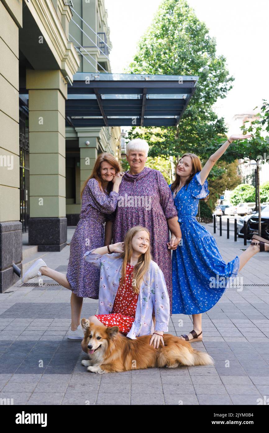 feliz generación femenina - madre, abuela, nietas y perro corgi Foto de stock