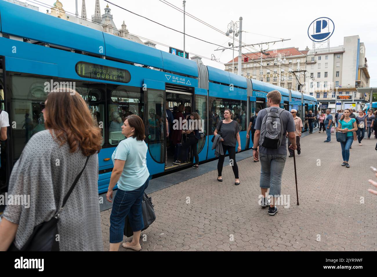 Tranvía azul moderno y pasajeros de embarque y desembarque en la plaza Ban Jelacic en Zagreb, Croacia, Europa Foto de stock