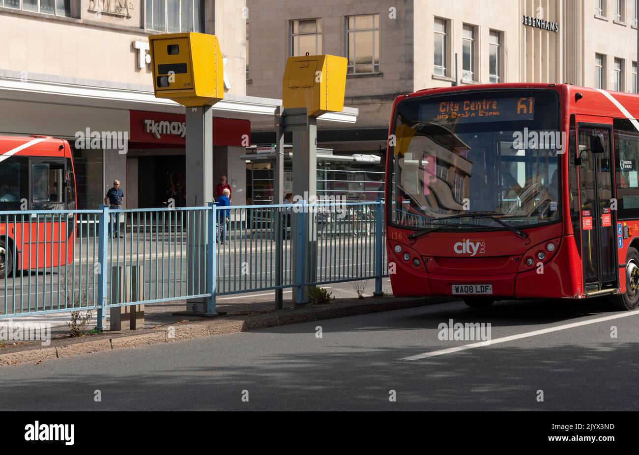 Plymouth, Devon, Inglaterra, Reino Unido. 2022, Red City Bus que se aproxima a dos radares de tráfico montados para registrar la velocidad del tráfico que se aproxima. Foto de stock