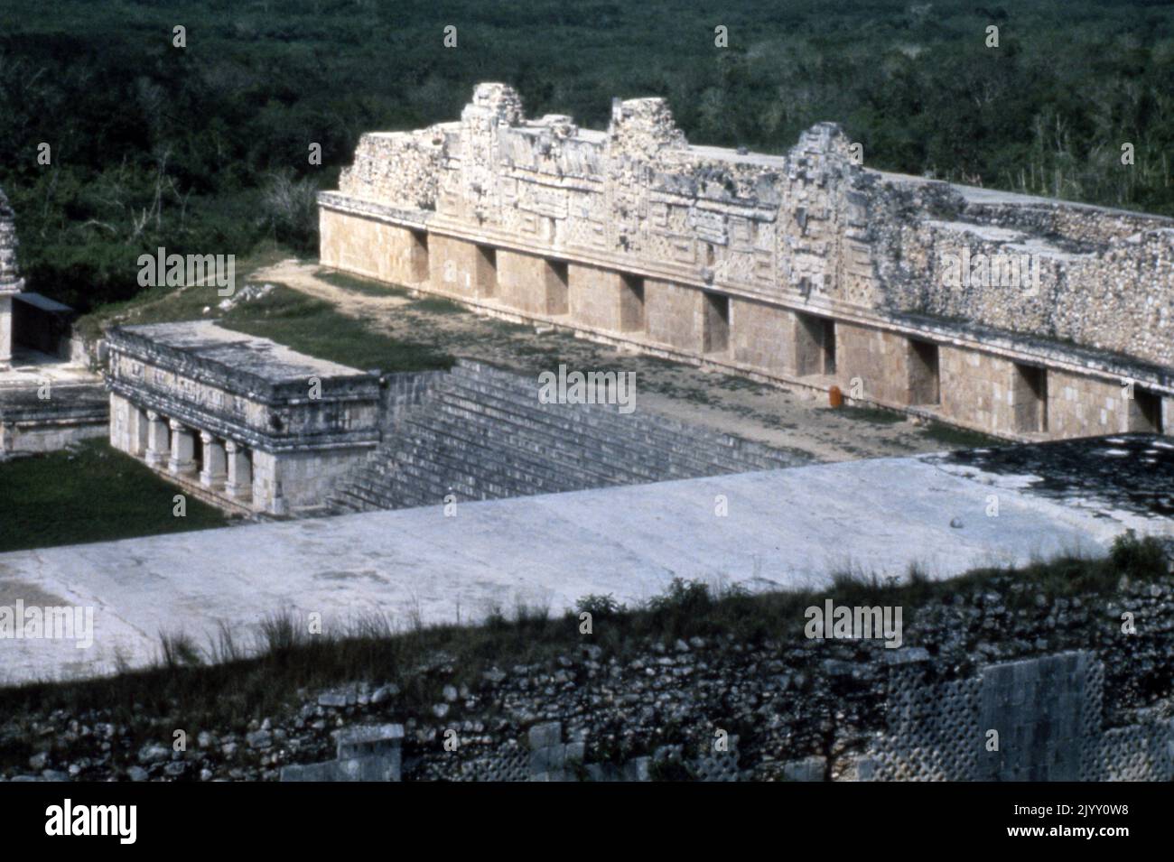 El convento de Uxmal, una antigua ciudad maya de la época clásica en el México actual. Considerado uno de los sitios arqueológicos más importantes de la cultura maya. El edificio es típico del estilo Puuc, con paredes bajas suaves que se abren sobre frisos ornamentados. La mayor parte de la construcción mayor de la ciudad tuvo lugar mientras que Uxmal era la capital de un estado maya del Clásico Tardío alrededor del año 850-925 DC. Después de alrededor de 1000 dC, invasores toltecas tomaron el control. El Cuadrángulo del Convento (un apodo dado a él por los españoles; era un palacio del gobierno) es el mejor de los varios cuadrángulos finos de edificios largos de Uxmal. Tiene elabo Foto de stock