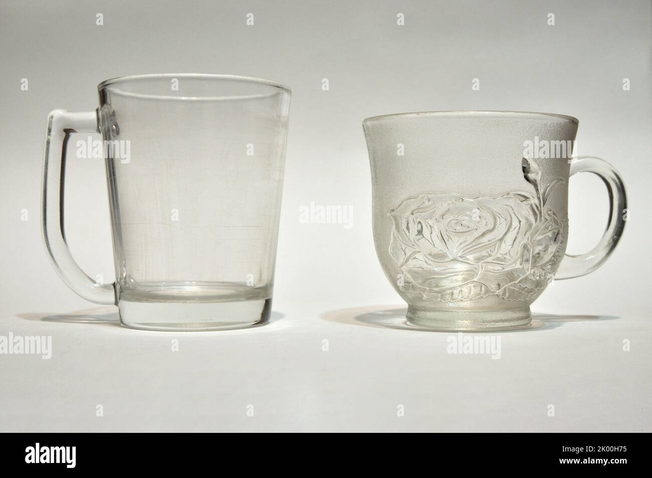 Tazas vacías, dos vasos usados sobre fondo blanco, vidrio transparente Foto de stock