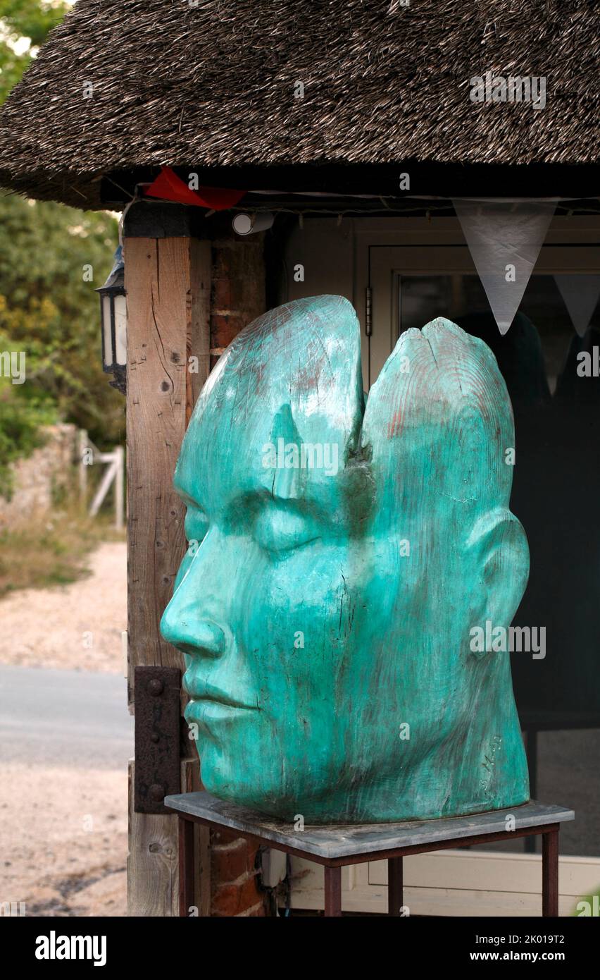 Gran cara de madera tallada, pintada de verde o aguamarina. Una exposición en la finca Symondsbury, Dorset. REINO UNIDO Foto de stock