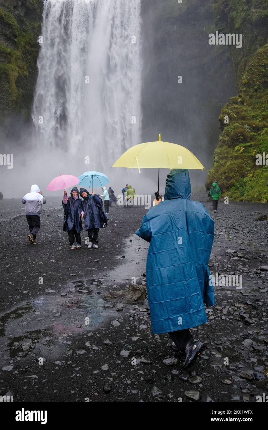 Turistas posando para fotografías en Skogafoss, Islandia Foto de stock