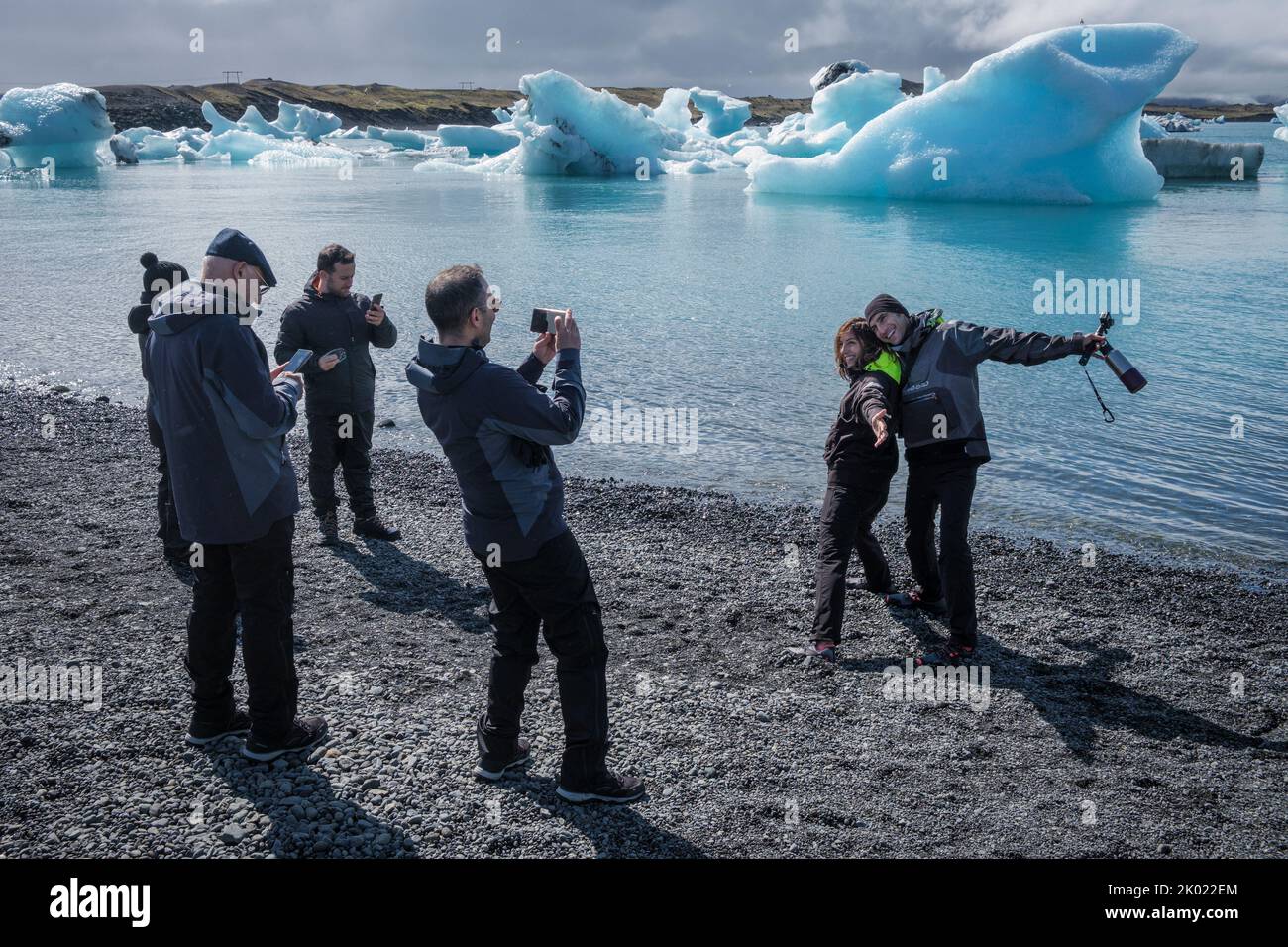 Turistas posando para fotos de icebergs en la laguna glacial de Jokulsarlon, Islandia Foto de stock