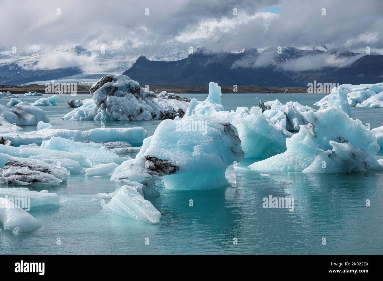 Icebergs que se han desprendido del glaciar Breidamerkurjokull flotando hacia el mar en la laguna glacial Jokulsarlon, Islandia Foto de stock