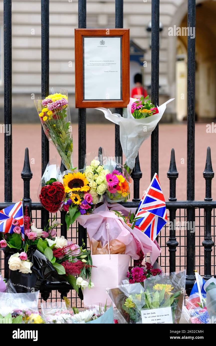 Palacio de Buckingham, Londres, Reino Unido – Viernes 9th de septiembre de 2022 – Las flores y las banderas ahora rodean el aviso oficial de muerte de la Reina Isabel II en las afueras del Palacio de Buckingham. Foto Steven May / Alamy Live News Foto de stock