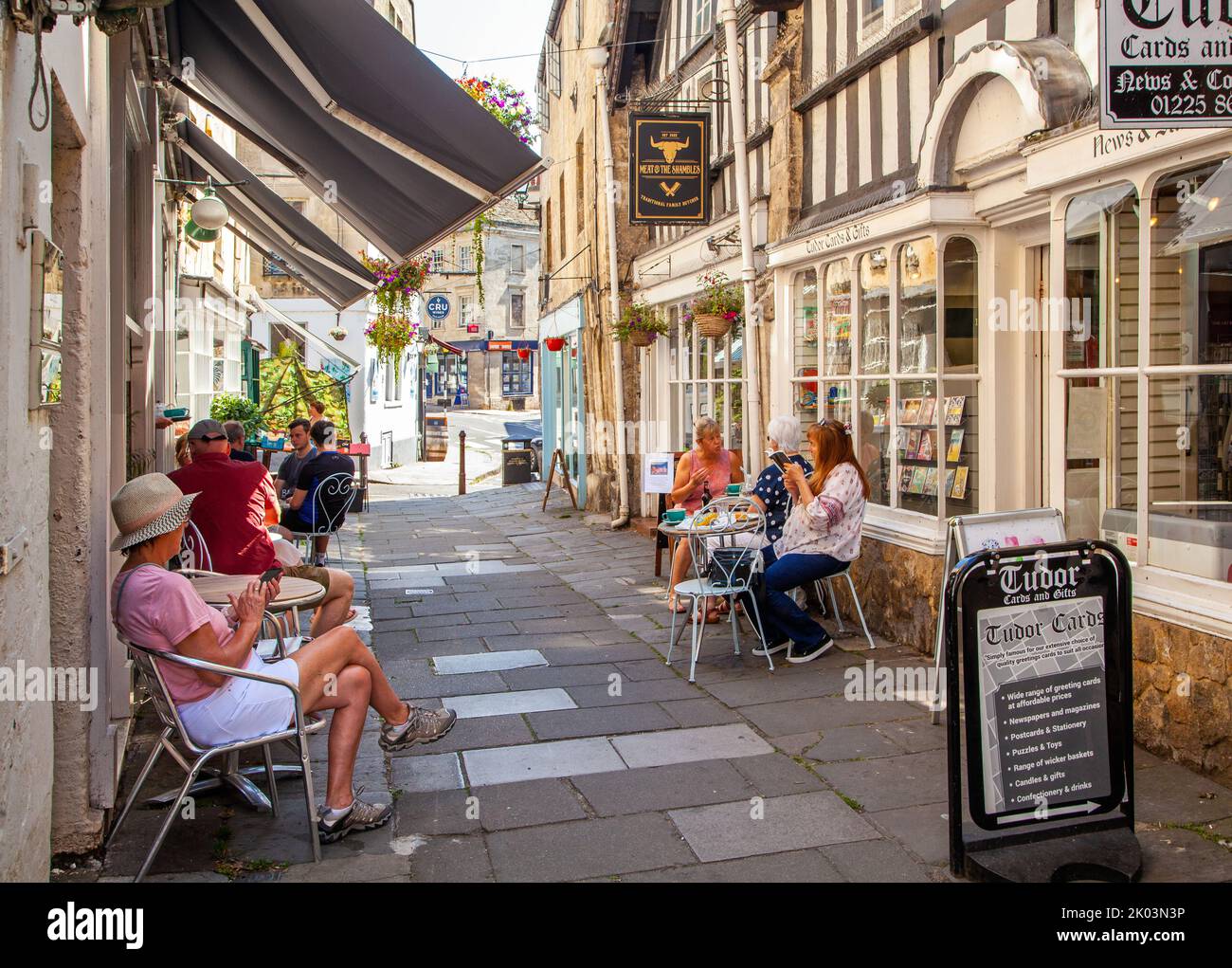 Gente sentada comiendo y bebiendo en cafés en los Shambles en la ciudad del mercado de Wiltshire de Bradford en Avon Foto de stock