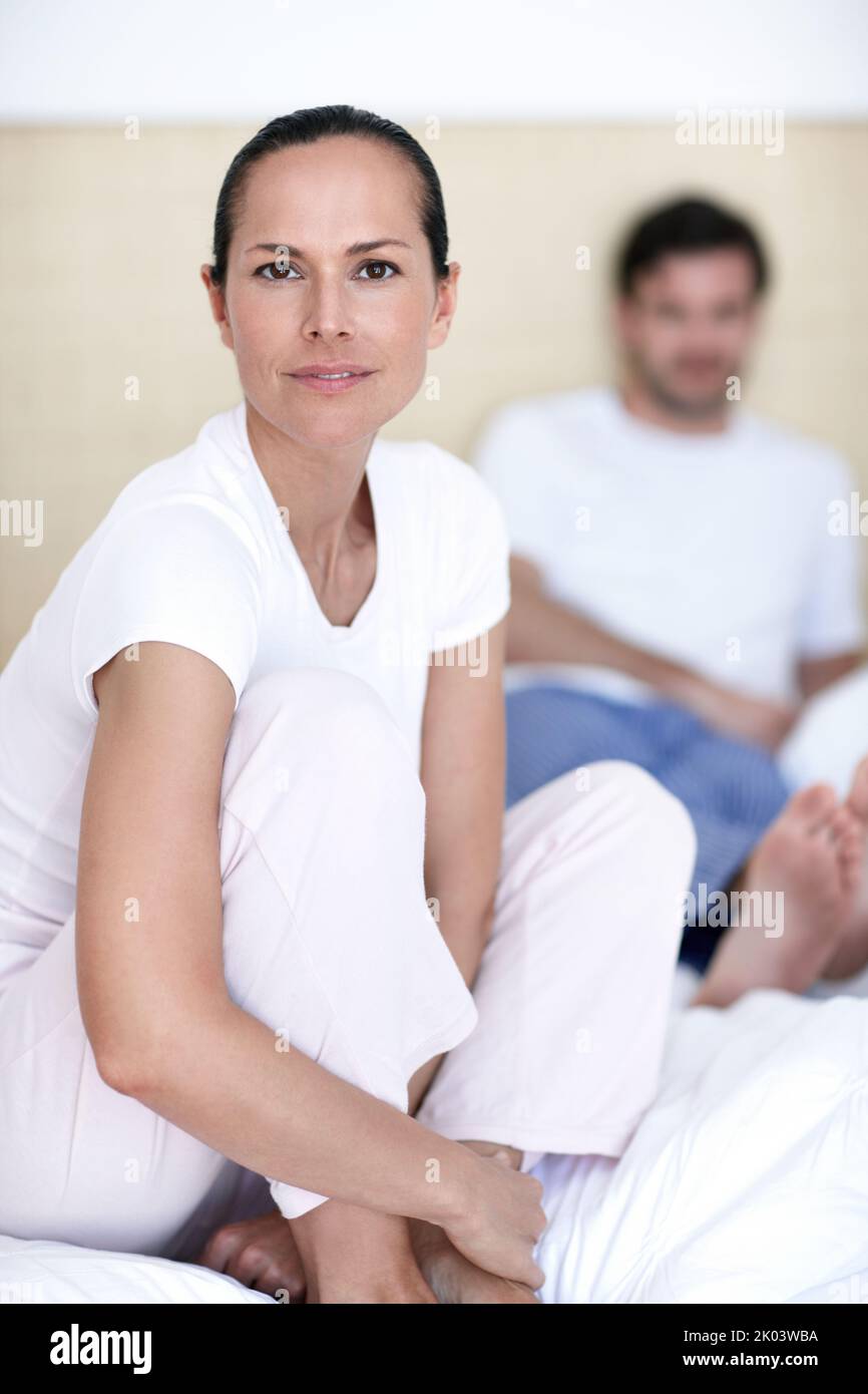 Hombre sentado con las piernas cruzadas en la cama fotografías e