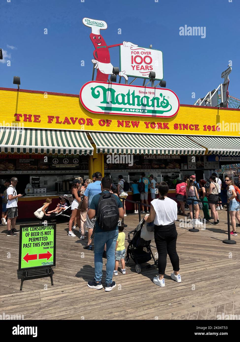 Personas que se alinean para Hot Dogs en el famoso Nathan's en el paseo marítimo de Coney Island en la playa de Brooklyn, Nueva York. Foto de stock