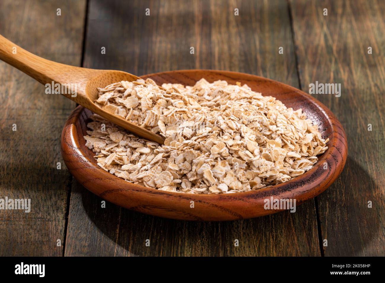 Copos de avena en el tazón de madera - Avena sativa Foto de stock