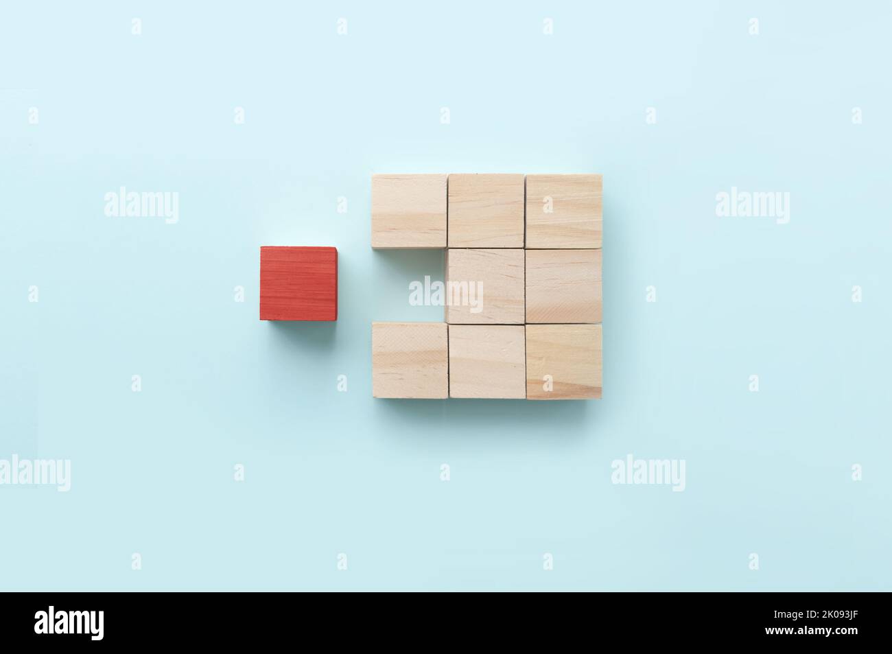 Bloque de madera rojo que destaca entre otras piezas del concepto de negocio Foto de stock