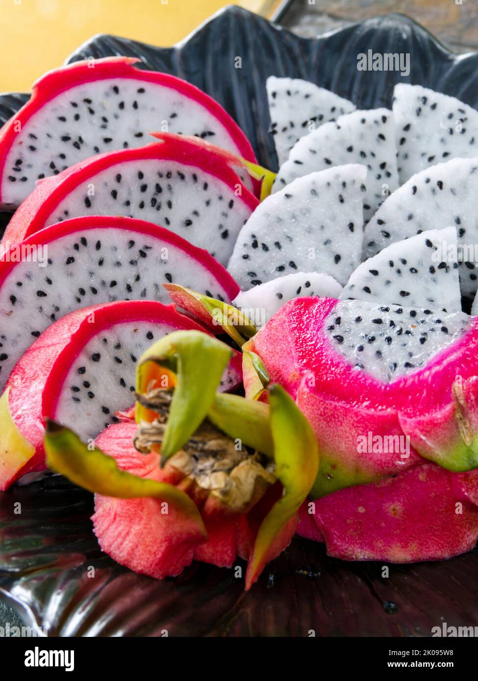 Plato de frutos de dragón en rodajas, pitahaya o pitaya, de la familia Cactaceae, fruto de varias especies de cactus. Foto de stock