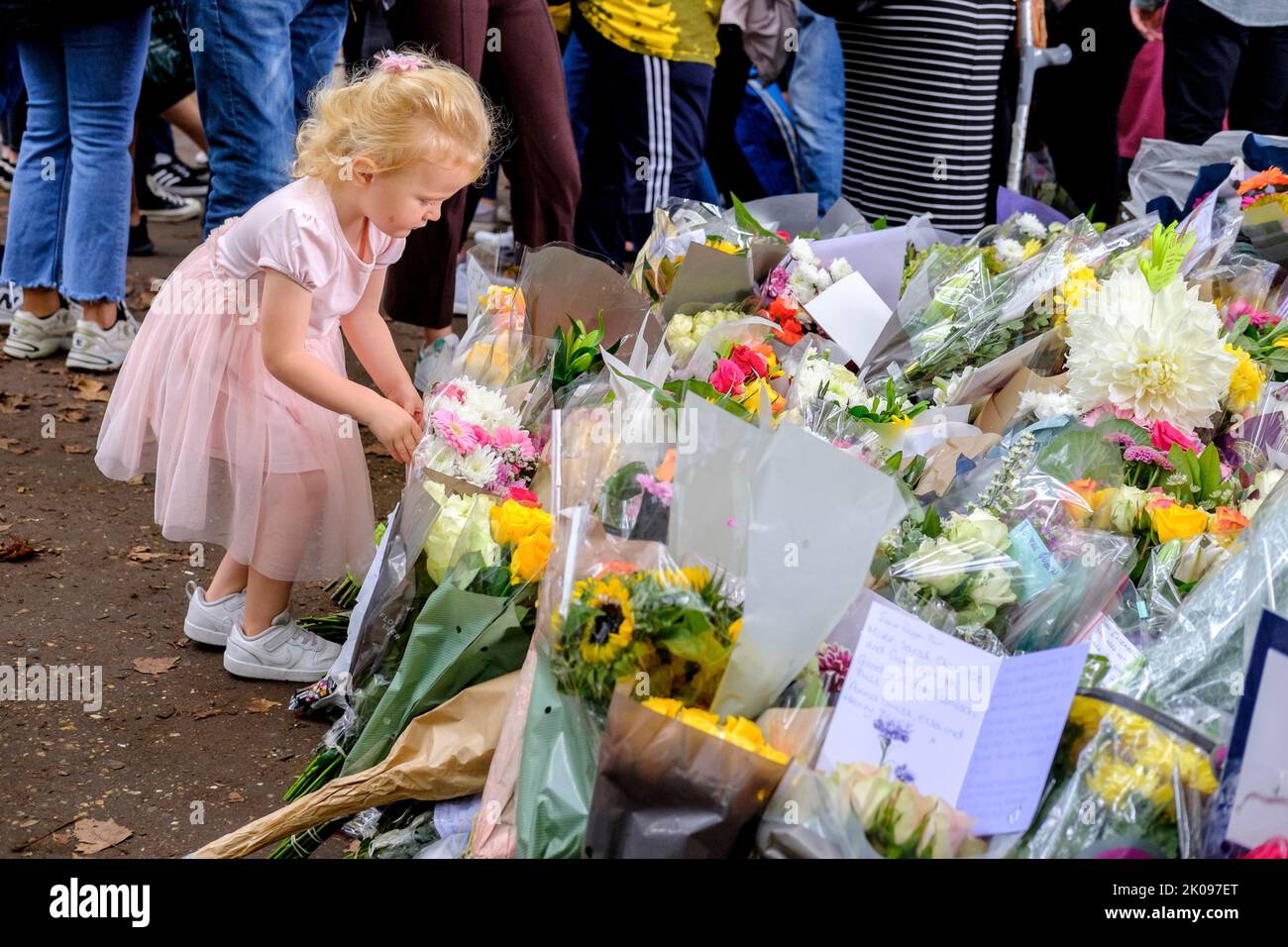 Londres, Reino Unido, 10th de septiembre de 2022. Miles de homenajes florales a Su Majestad la Reina Isabel II se depositan en Green Park, muchos de ellos acompañados por mensajes de adultos y niños. Un niño pone un ramo de flores. Foto de stock