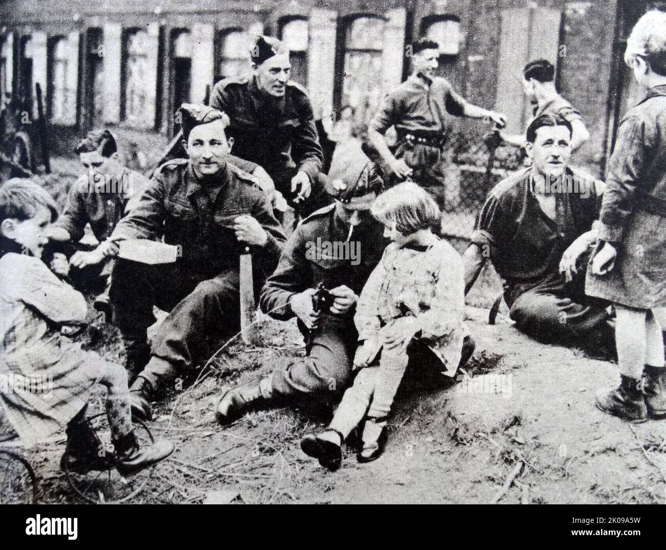 El cabo de Lance Batten con una niña francesa en la rodilla durante la Segunda Guerra Mundial Foto de stock