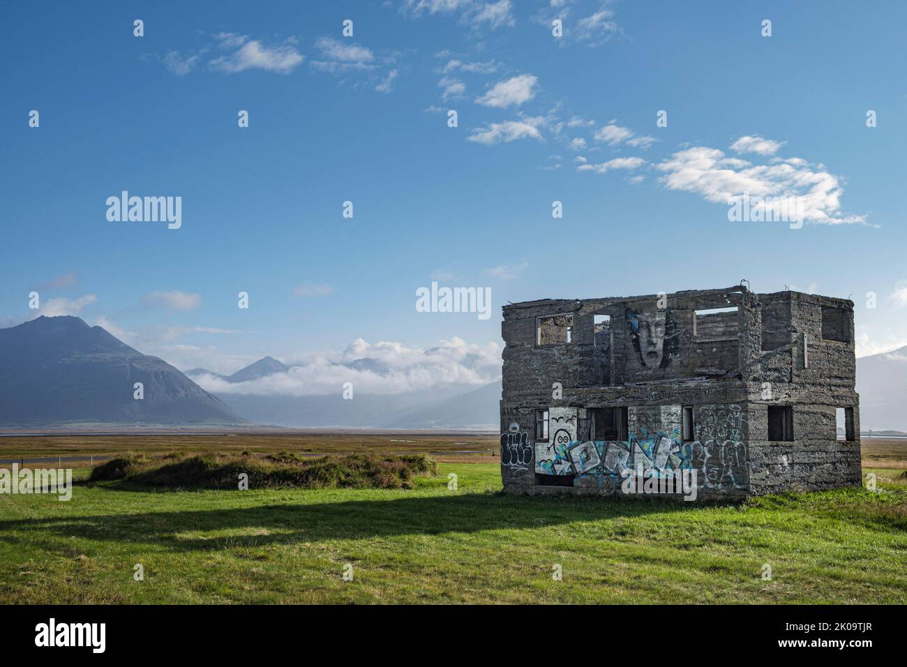 Un edificio abandonado cubierto de graffiti en tierras de labranza cerca de Hofn, Islandia Foto de stock