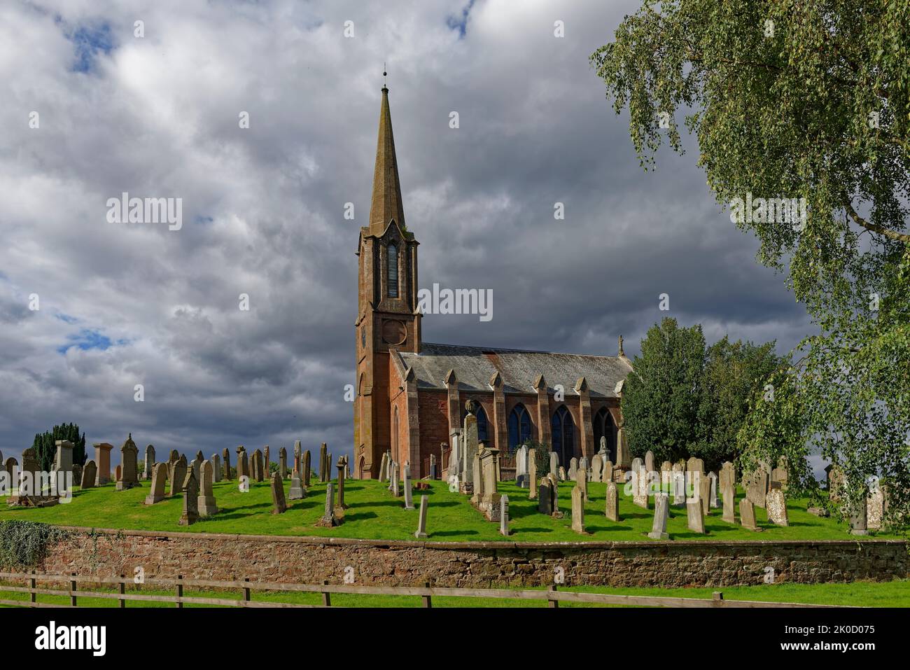 Nubes de lluvia amenazando sobre la Iglesia Parroquial y Graveyard en la pequeña aldea de Aberdeenshire de Fettercairn. Foto de stock
